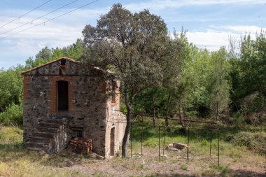 Terk edilmiş eski ahşap bir ev, kırık bir çatı ve İspanya 'da ağaçlar.