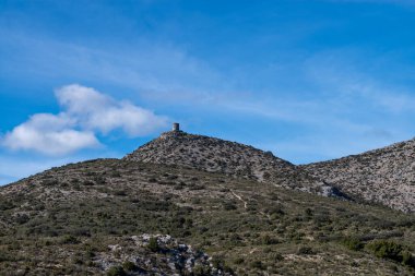 Bulutlu bir havada bir dağın tepesinin dikey görüntüsü.