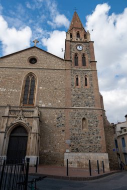 Mavi gökyüzünün arka planında çan kulesi olan bir kilisenin cephesi.