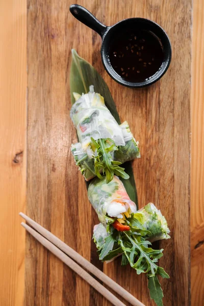 Rolos de primavera com camarão, pauzinhos de madeira e molho de soja. Cozinha asiática. Imagem De Stock
