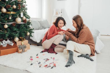 İki bayan arkadaş manikür yapıyor.