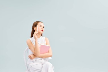 Gelecek Planları 'nı düşünüyorum. Not Defteriyle Oturan Dalgın Asyalı Kız 