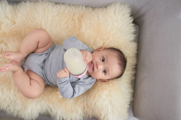 Menina Bebê Segurando Alimentando Leite Garrafa Deitada Sofá — Fotografia de Stock