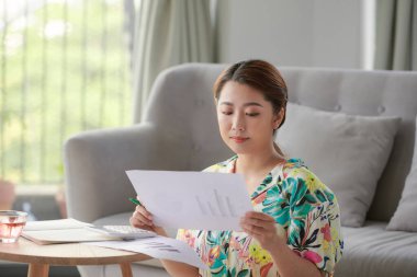 Mutlu kendini istihdam cheching kağıt dosyaları bir tabloda evde