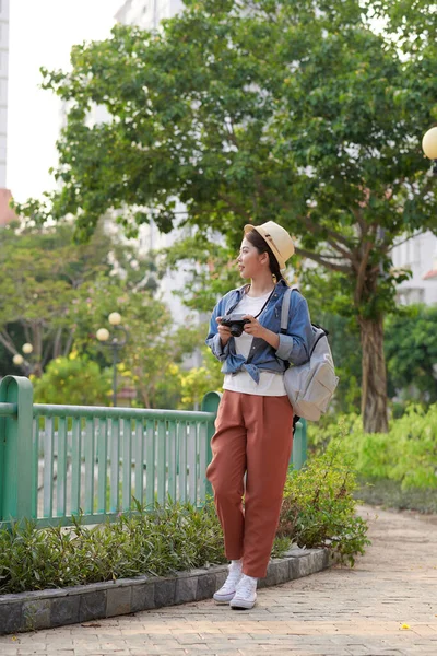 年轻美丽的亚洲背包客女人用数码相机和微笑 看着复制的空间 — 图库照片