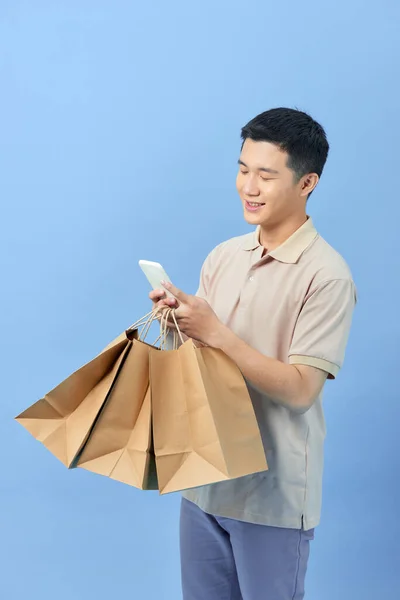아시아 젊은이 쇼핑백을 들고와 핸드폰 초상화를 — 스톡 사진