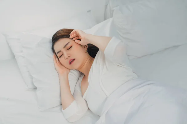 ベッドに横たわっながら頭痛の種の美しい若い女性 — ストック写真