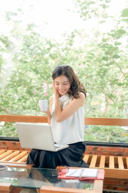 Neşeli, çekici bir insanın uzun bir portresi. Oturup netbook okuyarak evde çalışmanın keyfi yerine geliyor.