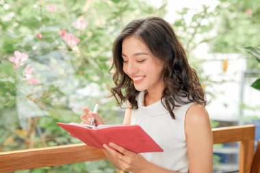 Evdeki kanepede günlük okuyan kadın.