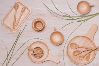 Yeni ahşap mutfak aletleri, kaseler, tabaklar, kaşıklar, tabaklar. Stüdyo çekimi ahşap arkaplanda izole edildi