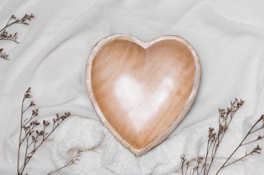 Masanın üzerinde kalp şeklinde ahşap tabak var..