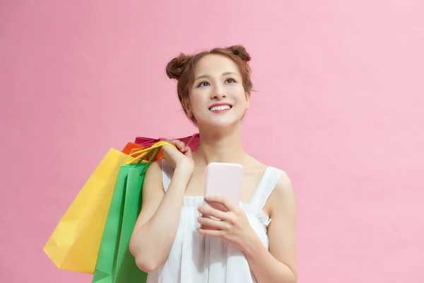 时尚漂亮的年轻亚洲女人 带着五颜六色的购物袋 带着手机上网购物 — 图库照片
