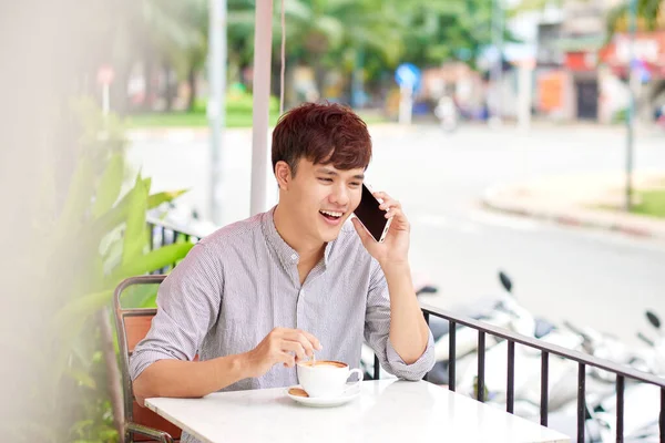 若いですハンサムな男は 携帯電話で話している間にカフェの屋外に座って — ストック写真