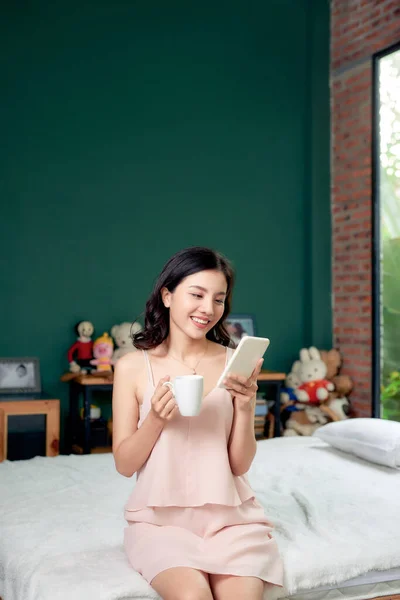 Beautiful Young Asian Woman Using Smartphone Holding Coffee Cup While — Stock Photo, Image