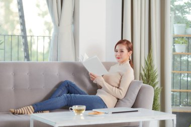 beautiful woman  on the sofa with book