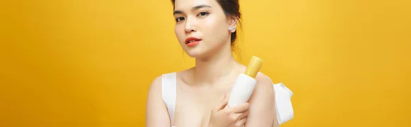 Portrét Asijské Ženy Která Drží Produkt Krásy Přes Žluté Pozadí — Stock fotografie