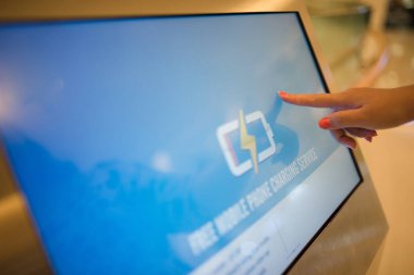 Alışveriş merkezindeki dokunmatik ekranda kadın elinin yakın plan görüntüsü.