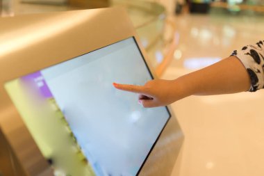 Alışveriş merkezindeki dokunmatik ekranda kadın elinin yakın plan görüntüsü.