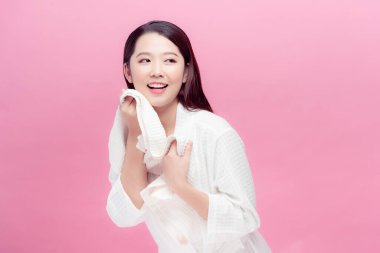 Asyalı genç bir kadın beyaz havlu kullanıyor. Temiz cilt.