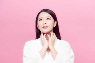 Pembe arka planda temiz ciltli güzel Asyalı bir kadın.
