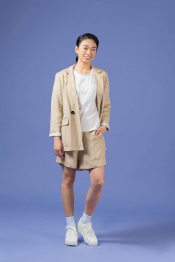 Kendinden emin serbest kadın fotoğrafı. Haki takım elbise giy. Mor arka plan izole edilmiş.