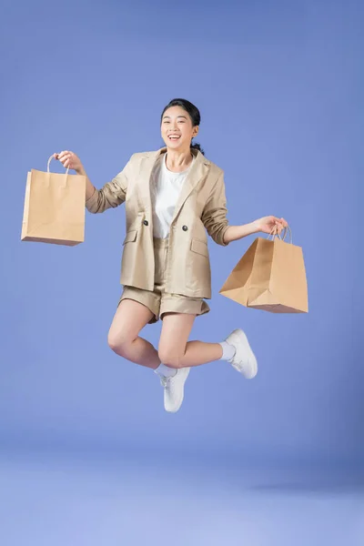 Uma Menina Sorrindo Segurando Sacos Compras Enquanto Saltava Isolado Sobre — Fotografia de Stock