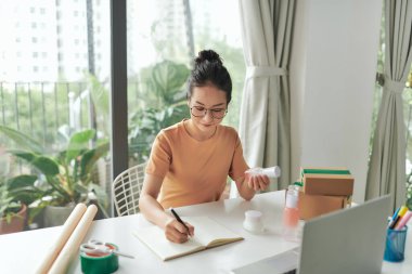 Kadın internet mağazasında satılmadan önce yeni ürünlerin kalitesini kontrol ediyor..