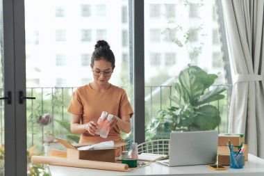 Çevrimiçi dükkanı için organik cilt ürünleri satan bir işyeri sahibi.