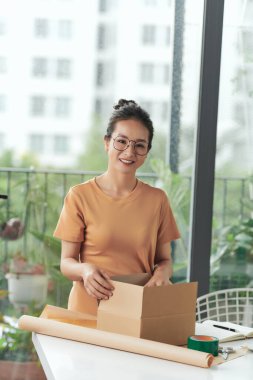 Küçük işletme sahibi iş yerinde karton kutu topluyor..