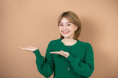 Güzel, Asyalı bir kadın, reklam vermek için güzellik avucunun üzerinde fotokopi alanı tutuyor. Ürününüz için kullanın.