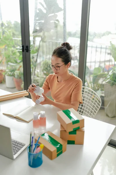 Başarılı Asyalı girişimci, el yapımı doğal ürünlerinin kalitesini kontrol ediyor.