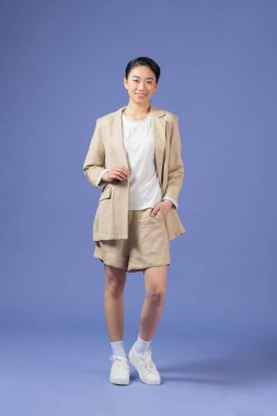 Mor arkaplan üzerinde izole edilmiş boş bir fotokopi alanı pozu veren çekici, neşeli kızın boy boy görünümü