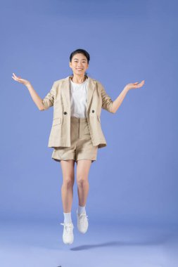 Mor arka planda tek başına zıplayan çekici çılgın menajerin tam boy portresi.