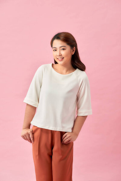 Портрет счастливой улыбающейся молодой красивой женщины, изолированной на розовом фоне