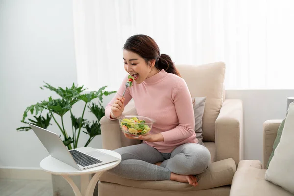 Mulher Bonita Comendo Uma Salada Saudável Sala Estar Usando Computador — Fotografia de Stock