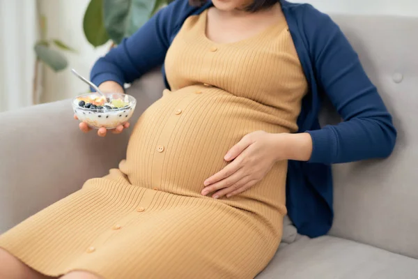 Feliz Asiática Embarazada Joven Sentada Comiendo Ensalada Frutas Sofá Casa — Foto de Stock