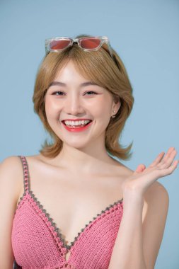 Pozitif model mavi duvarın yanında güneş gözlükleriyle eğleniyor.