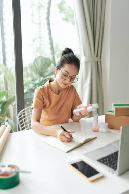 Serbest kadın satıcı müşterilere teslimat için ürün siparişini kontrol et.