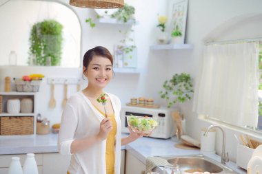 çekici bir kadın bir salata mutfakta yemek