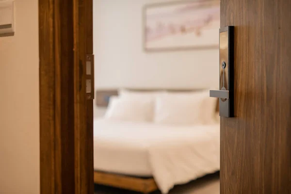 Hotel room opened with digital door access control, Condominium or apartment doorway with open door in front of blur bedroom background