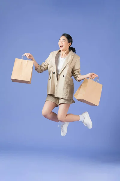 Attractive Happy Girl Jumping Shopping Bags Isolated Purple — Fotografia de Stock