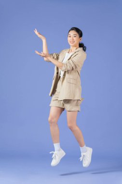 Mor arka planda tek başına zıplayan çekici çılgın menajerin tam boy portresi.