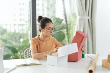 freelance woman seller prepare parcel box of product for deliver to customer.