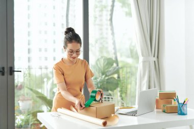 Başlangıçta küçük işletme sahibi evde çalışıyordu, kadınlar karton kutuyu yapışkan bantla kapatıyordu,