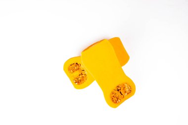 İki yarım soyulmuş olgun balkabağı ve beyaz arka planda izole edilmiş tohumlar. Yarım Tereyağlı Kabak. Balkabağı sağlıklı bir diyet için yararlı bir üründür. Sonbahar meyveleri ve sebze konsepti.