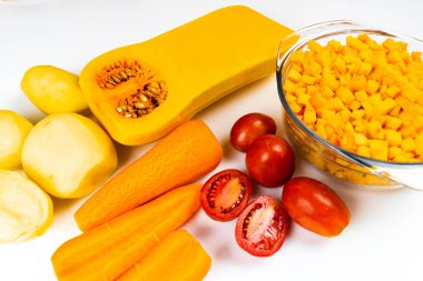 Balkabağı çorbası için malzemeler. Beyaz arka planda doğranmış kabak, havuç, patates, domates ve kabak kabağı kabağı (Cucurbita moschata). Düzgün beslenme için sonbahar sebzeleri.