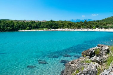 Plavi Horizonti plajı. Yaz güneşli manzarası. Radovici. Tivat Körfezi. Karadağ 'ın en güzel plajlarından birinde Mavi Bayrak yer alıyor. Temiz kum ve sığ su çocuklar için mükemmel..