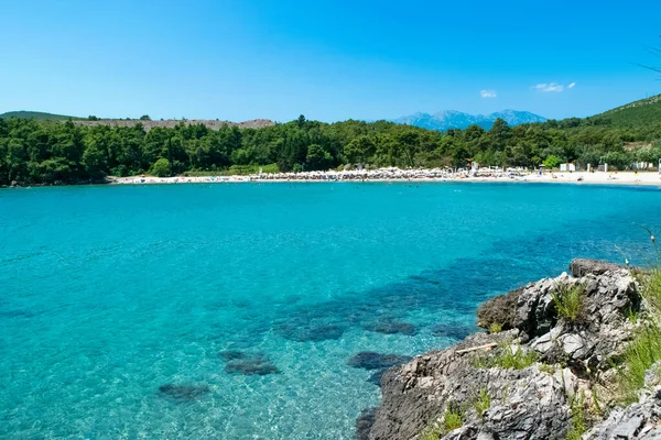 Plavi Horizonti plajı. Yaz güneşli manzarası. Radovici. Tivat Körfezi. Karadağ 'ın en güzel plajlarından birinde Mavi Bayrak yer alıyor. Temiz kum ve sığ su çocuklar için mükemmel..