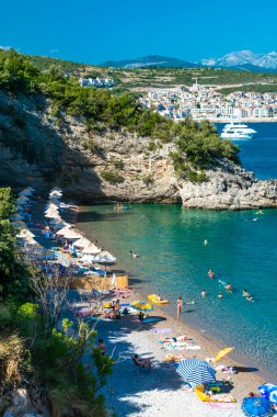 Velja Spila plajı, Karadağ - 28 Haziran 2021: Trashte Körfezi 'ndeki Lustica yarımadasında bulunan küçük çakıl taşı plajındaki tatilciler. Adriyatik Denizi. Yaz güneşli manzarası.