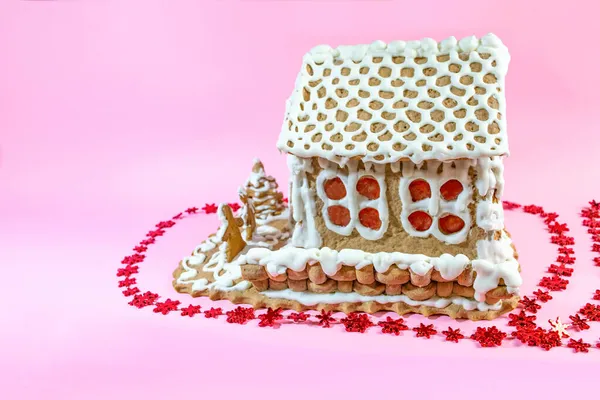 Hausgemachtes Lebkuchenhaus Bemalt Mit Weißem Süßem Zuckerguss Auf Rosa Hintergrund — Stockfoto